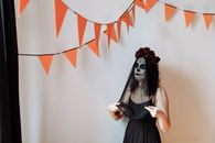 Woman in Black Sleeveless Dress With Red and White Headdress