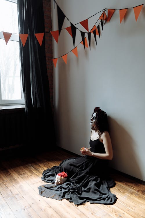 Woman in a Black Dress Sitting on the Floor