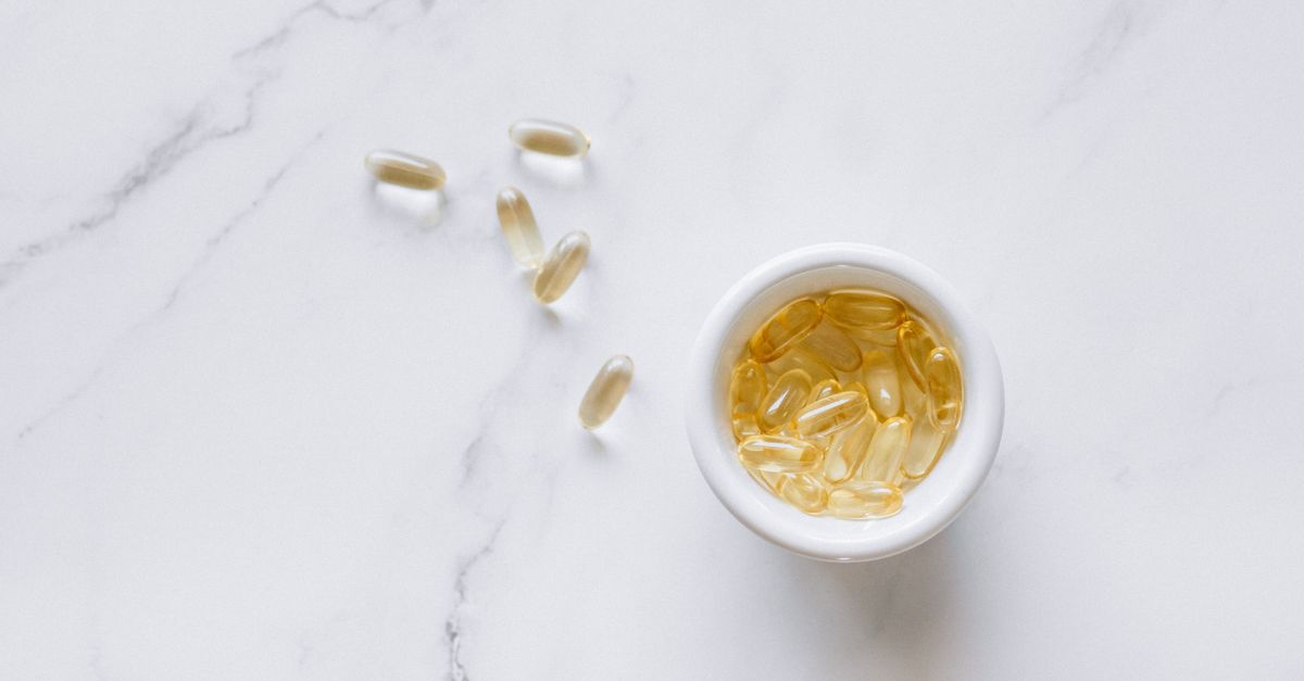 Top view of scattered capsules and a bowl on a marble surface, minimalistic setup. Top view of scattered capsules and a bowl on a marble surface, minimalistic setup.