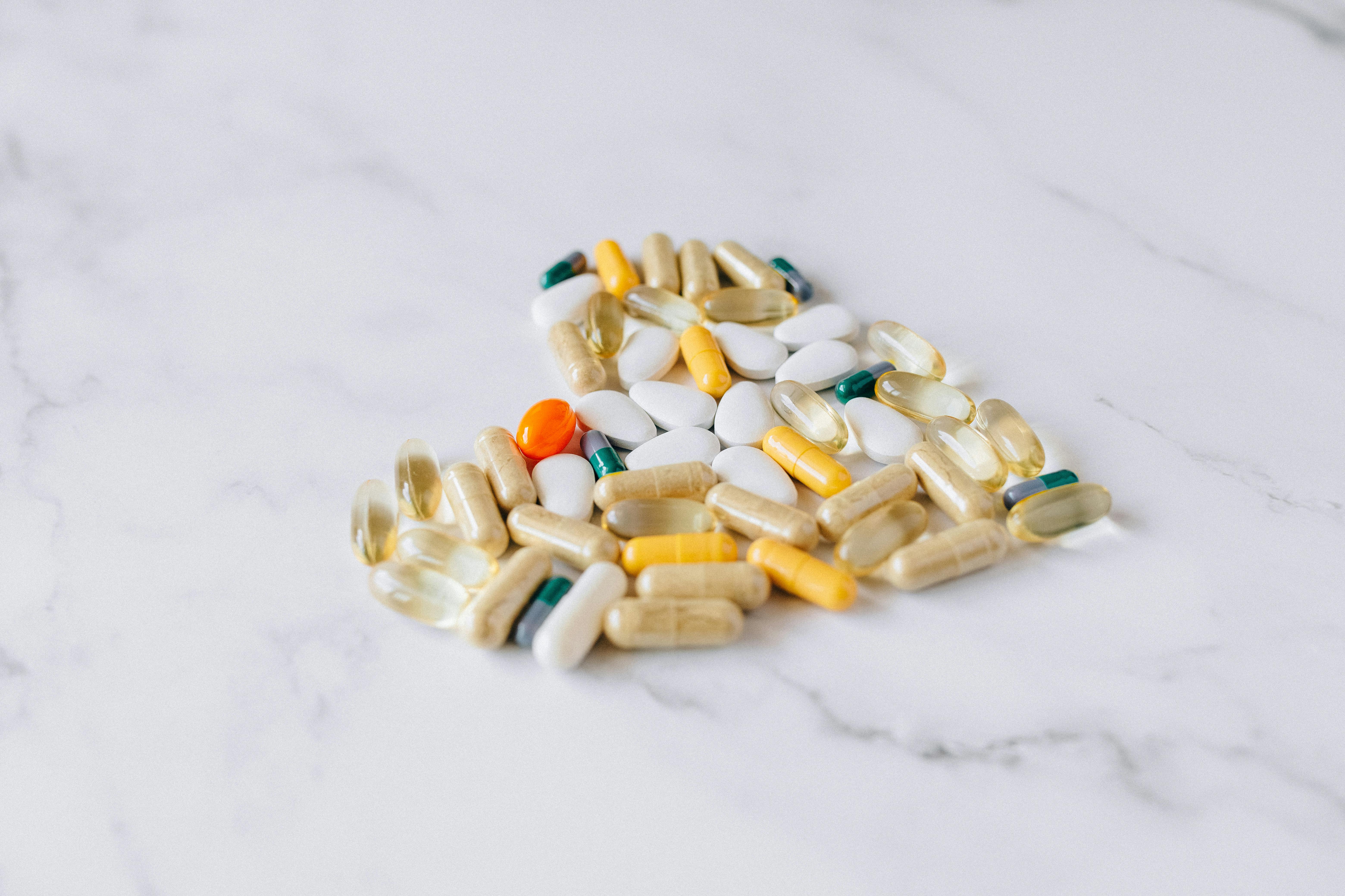 variety of supplements and pills on marble surface