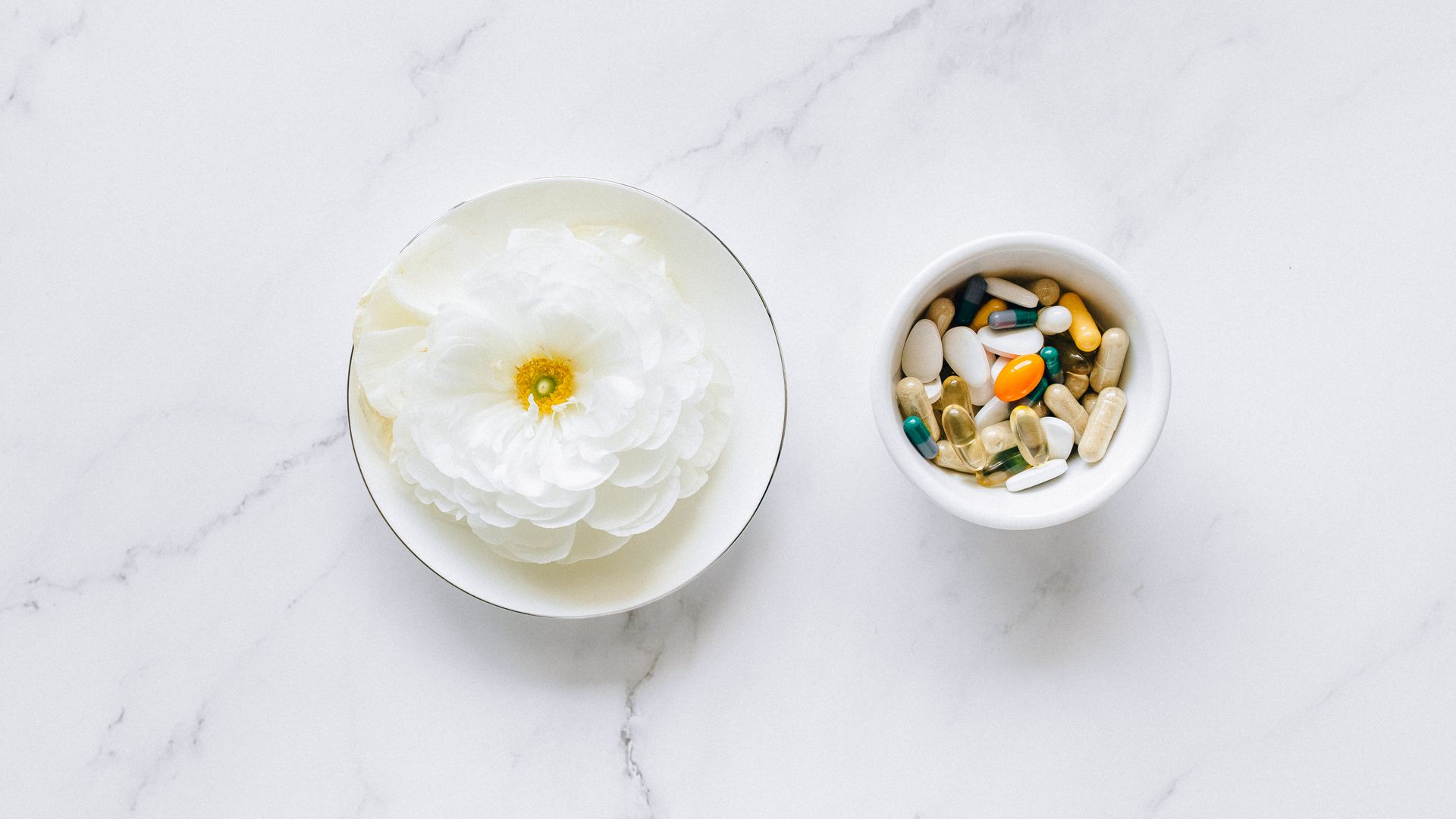 Modafinil Vendor Reviews Comparison: Unveiling the Best Sources Flat lay of a white flower next to mixing pills on a marble surface, symbolizing natural vs synthetic remedies — modafinil vendor reviews comparison