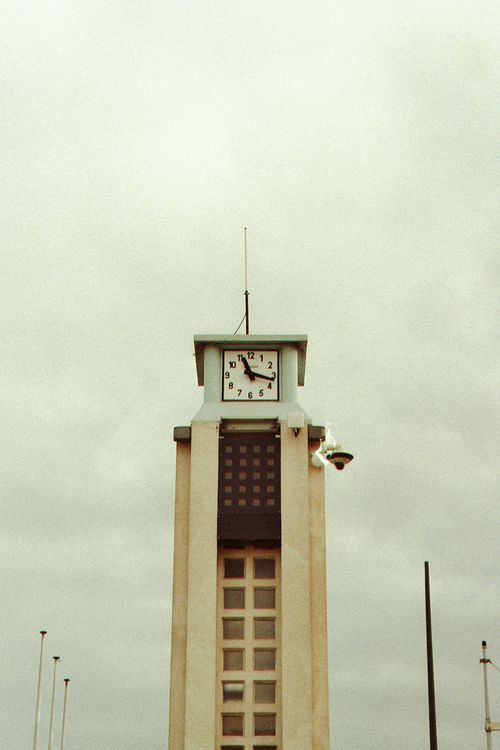 Free A vintage clock tower captured from a low angle under a gloomy, cloudy sky. Stock Photo