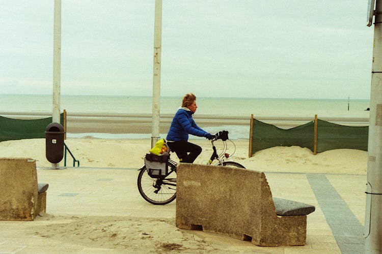 Woman Riding Bicycle Along Beach