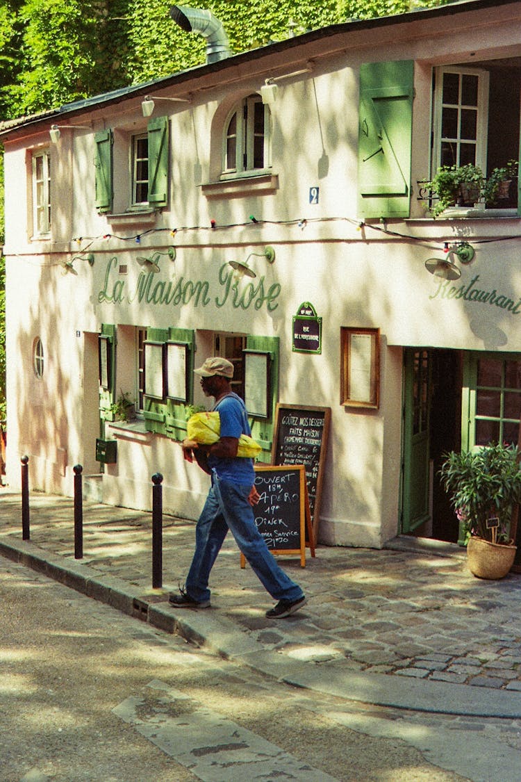 Man Walking Beside A Restaurant Building