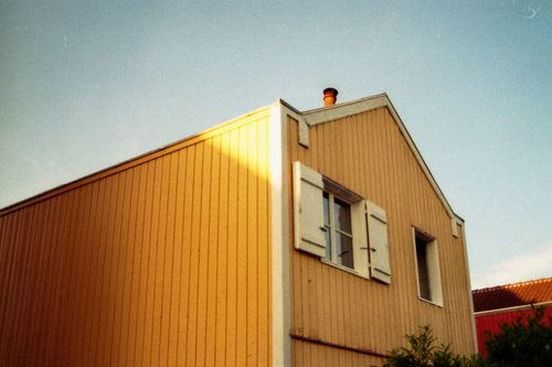 Free Vintage-style low angle view of a house facade with warm light and open shutter window. Stock Photo