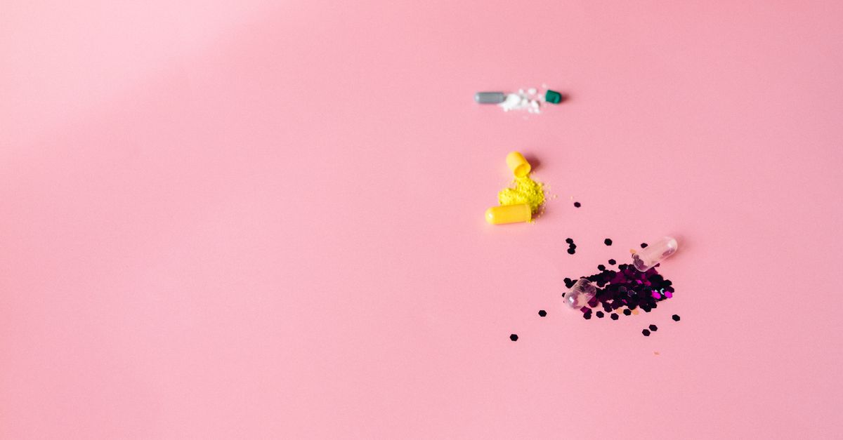 Open capsules on a pink surface