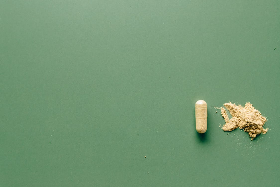 Free Medication Pill on Green Background Stock Photo