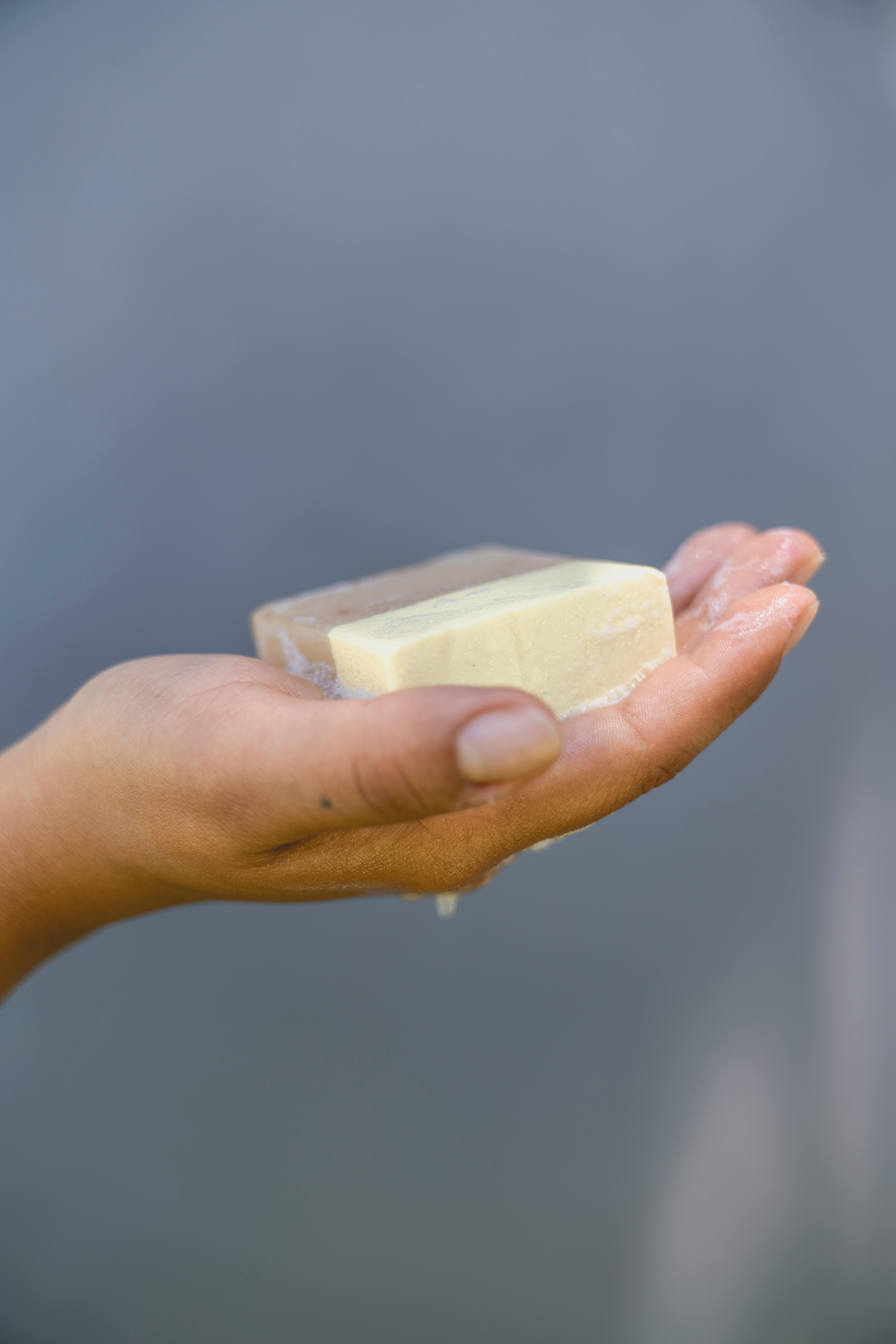 Detailed shot of a hand holding a bar of soap, emphasizing hygiene and skin care.
