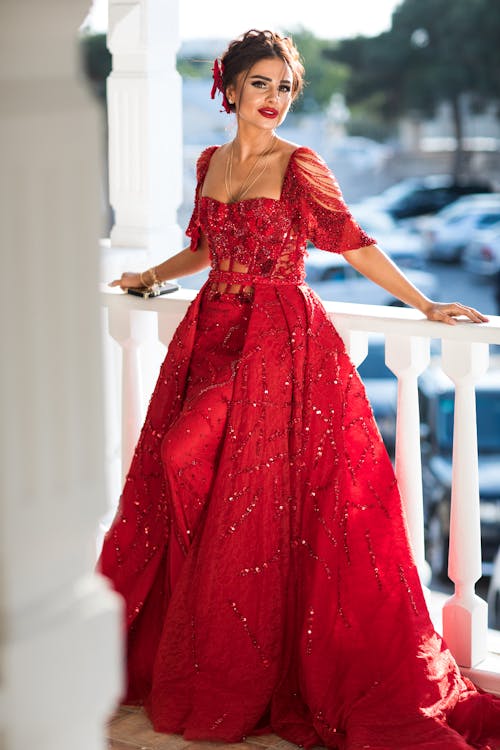 Woman Wearing Red Dress Posing Beside the Railing