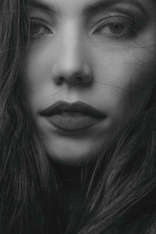 Free A close-up black and white portrait capturing the emotional expression of a woman. Stock Photo