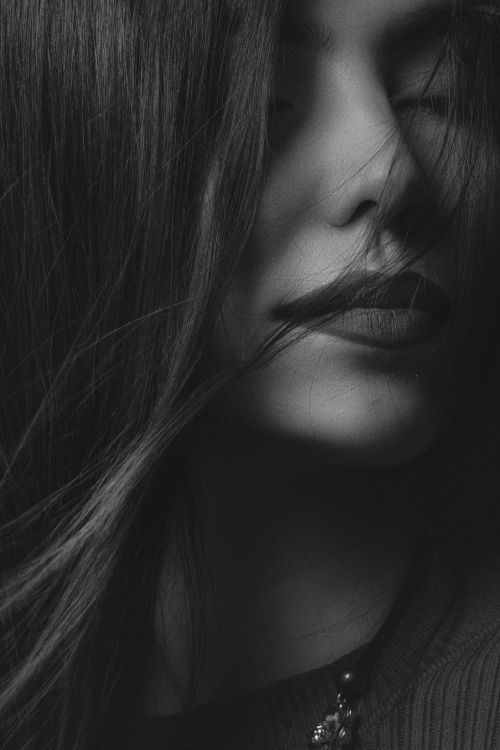 Free Dramatic black and white portrait of a woman with eyes closed, embracing elegance. Stock Photo