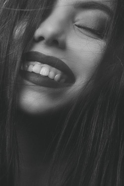 Grayscale Photo of a Woman Smiling