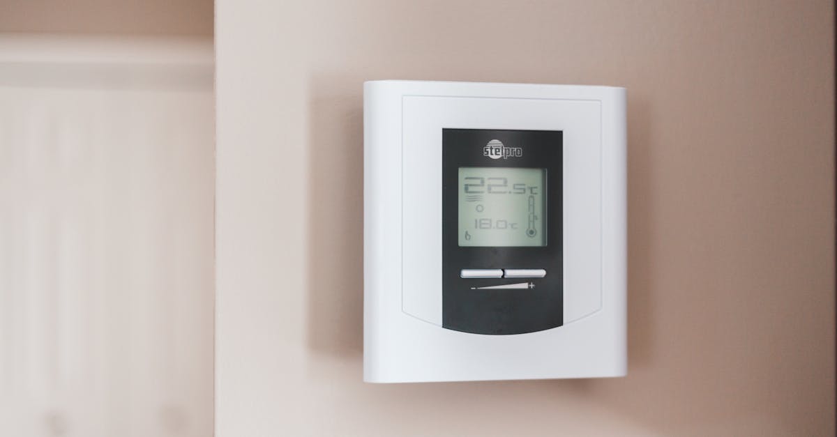 Smart thermostat displaying temperature settings on a wall, representing energy management and comfort in a smart home setup.