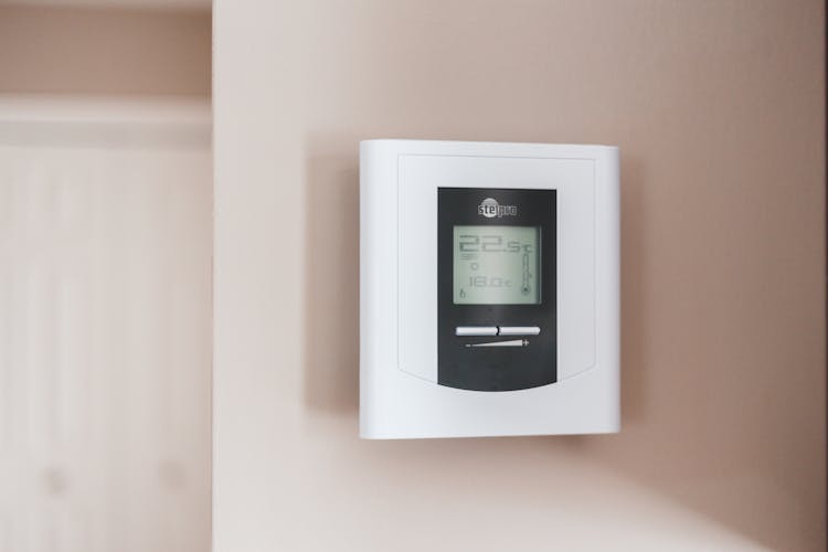 White Thermostat Hanging On The Wall