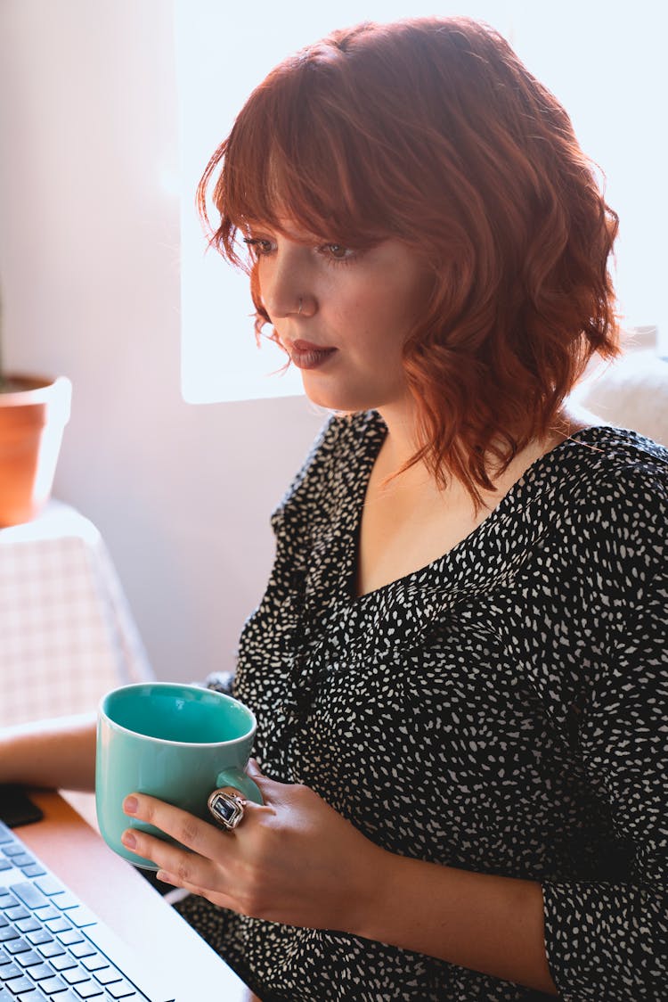 Woman In Black Blouse Holding A Cup