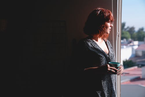 Free Woman Looking Outside while Holding a Mug Stock Photo