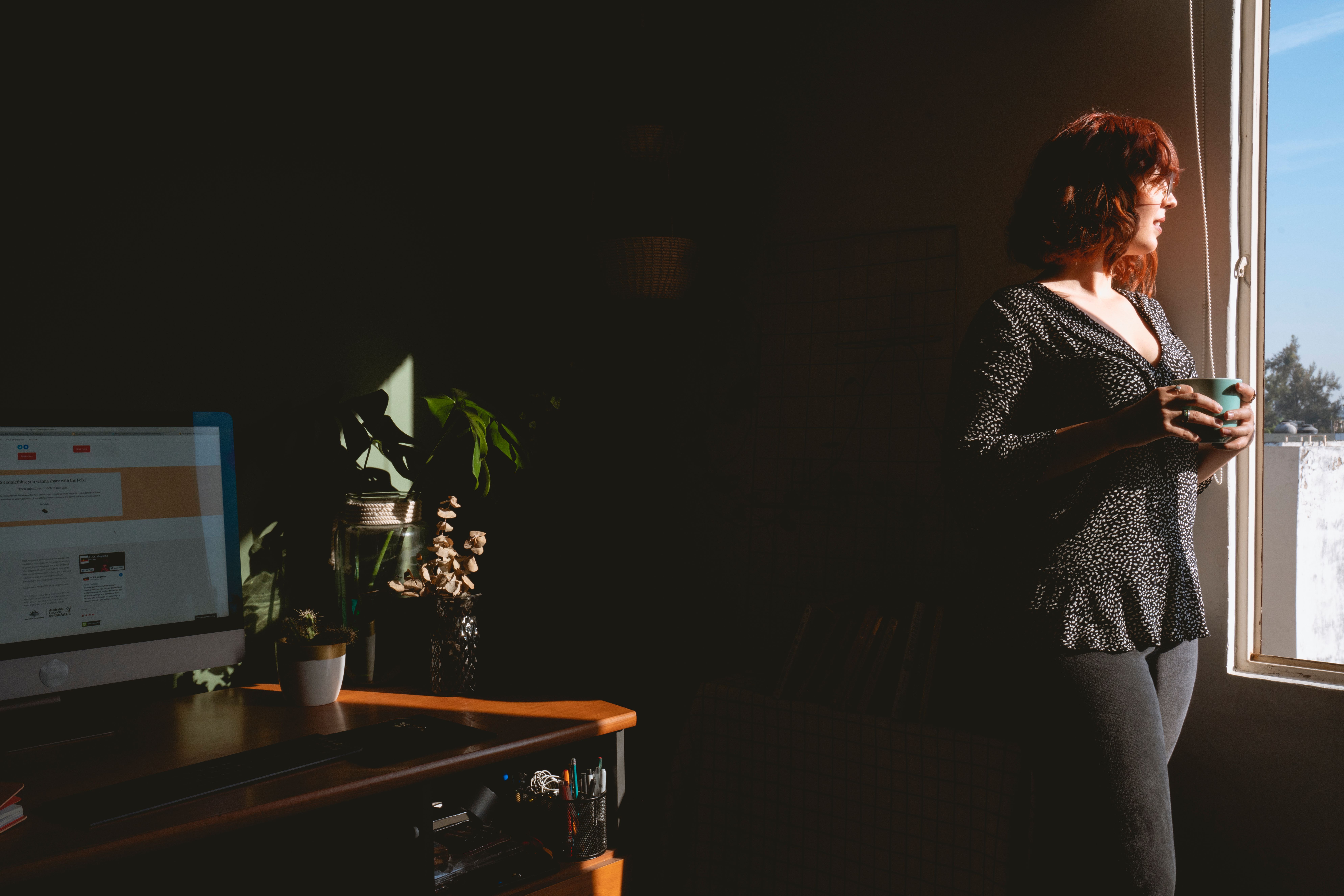 person sitting calmly at a desk with morning light, looking peaceful