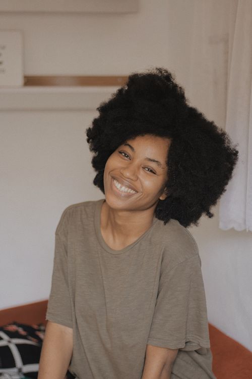 Smiling host sitting at home — Baptista Ime James on Pexels