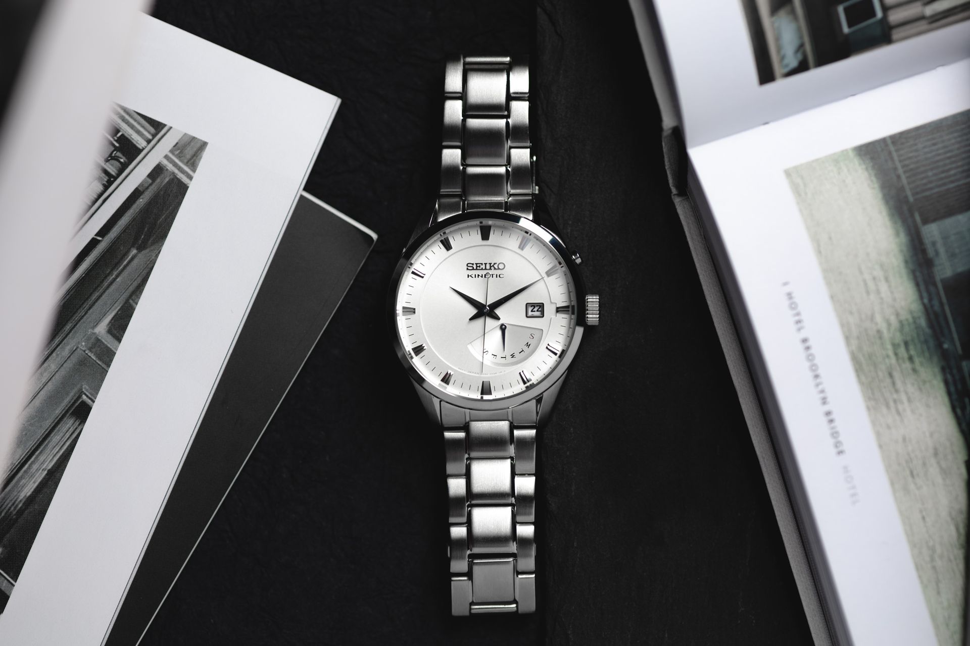Close-up of a Seiko stainless steel watch with books, emphasizing luxury and elegance.