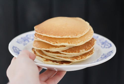 Person Holding Plate With Pancakes