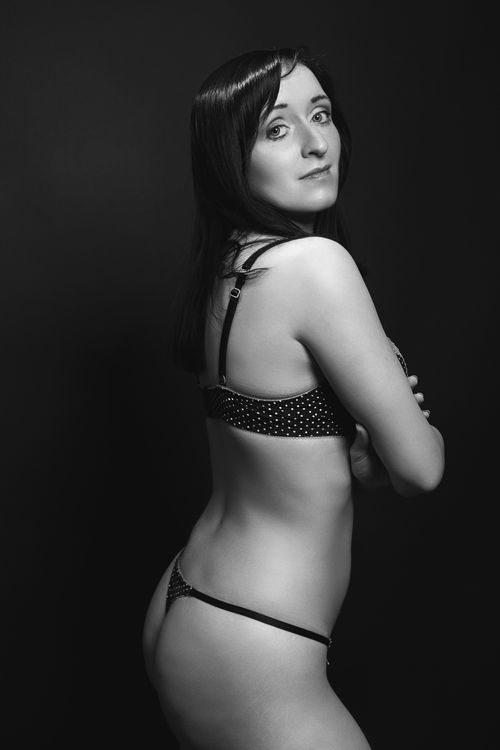 Free Artistic black and white portrait of a woman in polka dot lingerie, posing confidently. Stock Photo