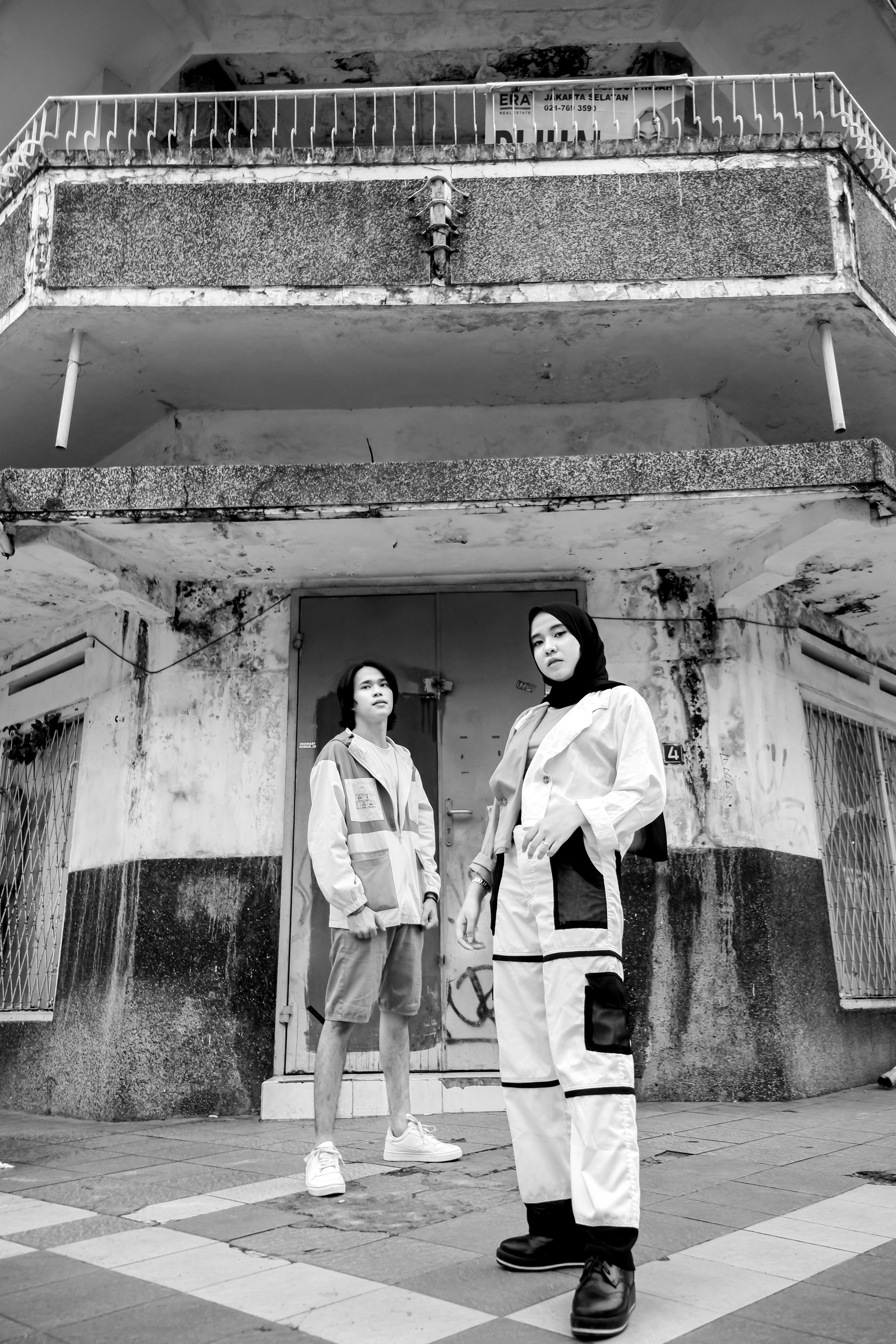 Free Stylish young adults pose in front of urban decay in black and white. Stock Photo