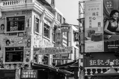 Free A vibrant urban street scene featuring vintage architecture and diverse billboards in grayscale. Stock Photo