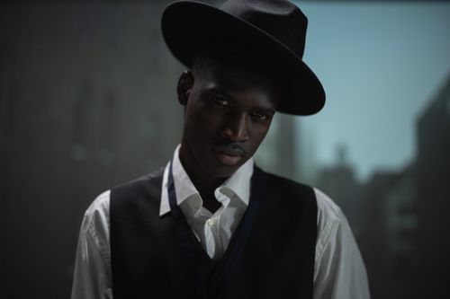 Free Close-up moody portrait of an African American man in a fedora hat and black vest. Stock Photo