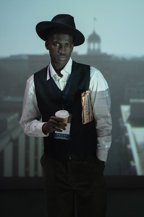 Free A Man in Black Vest Holding Paper Cup Stock Photo