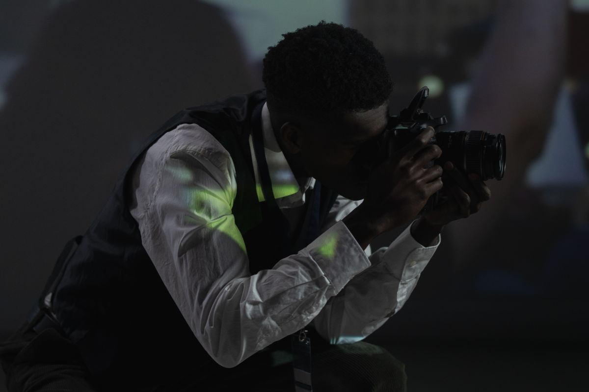 Photographe en plein tournage, caméra à l'épaule