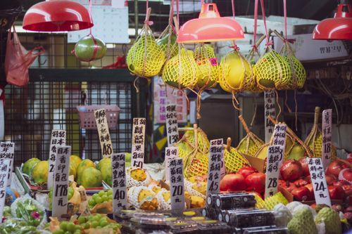 Free Colorful fruits and vegetables for sale under red lamps at a bustling Asian street market. Stock Photo
