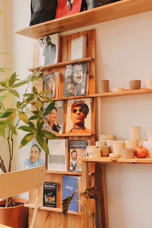 Free Wooden shelf displaying magazines, plants, and pottery for a cozy interior decor vibe. Stock Photo