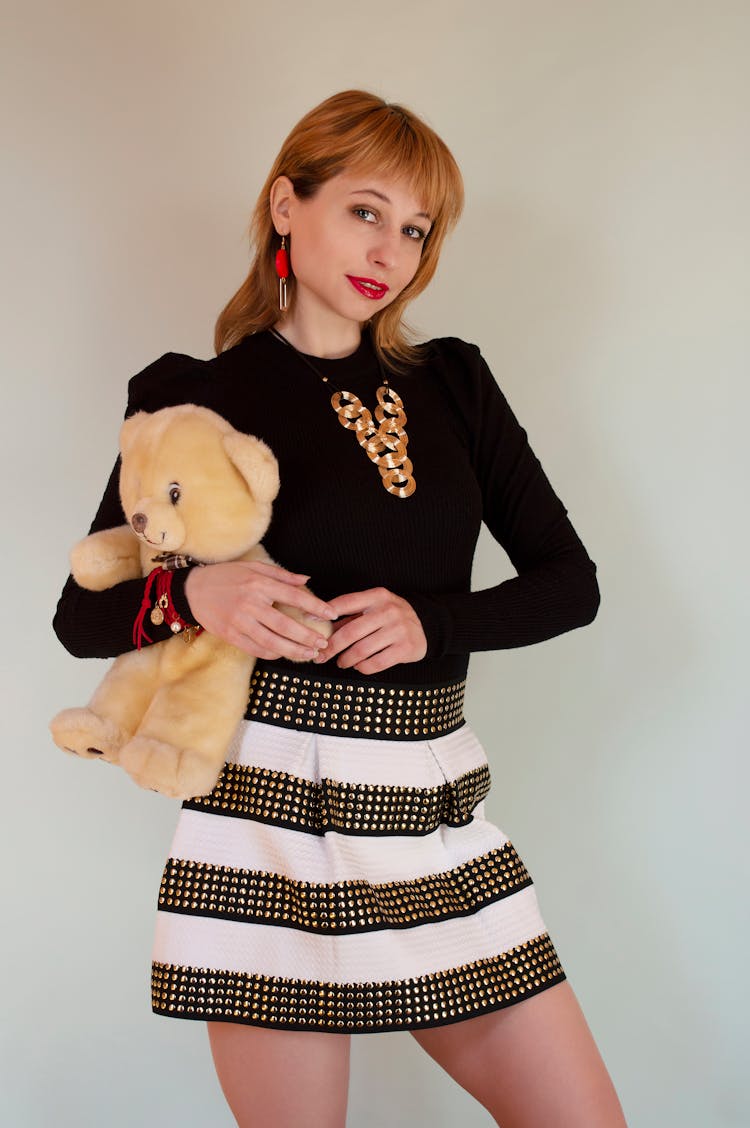 Charming Woman In Mini Skirt Holding Toy Bear