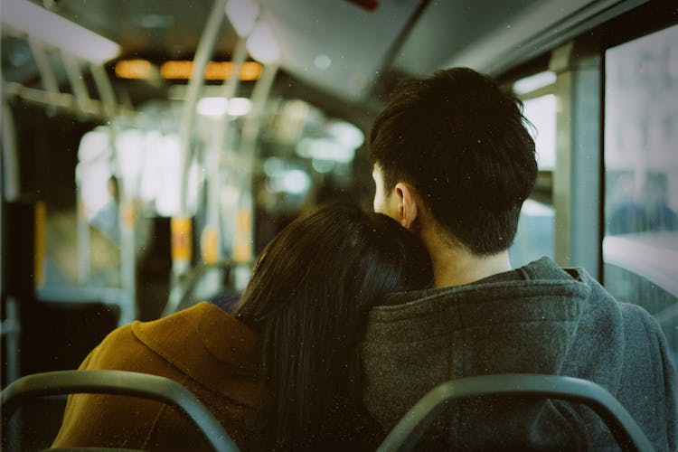 Woman Resting Her Head On Her Boyfriend Shoulder In A Bus 