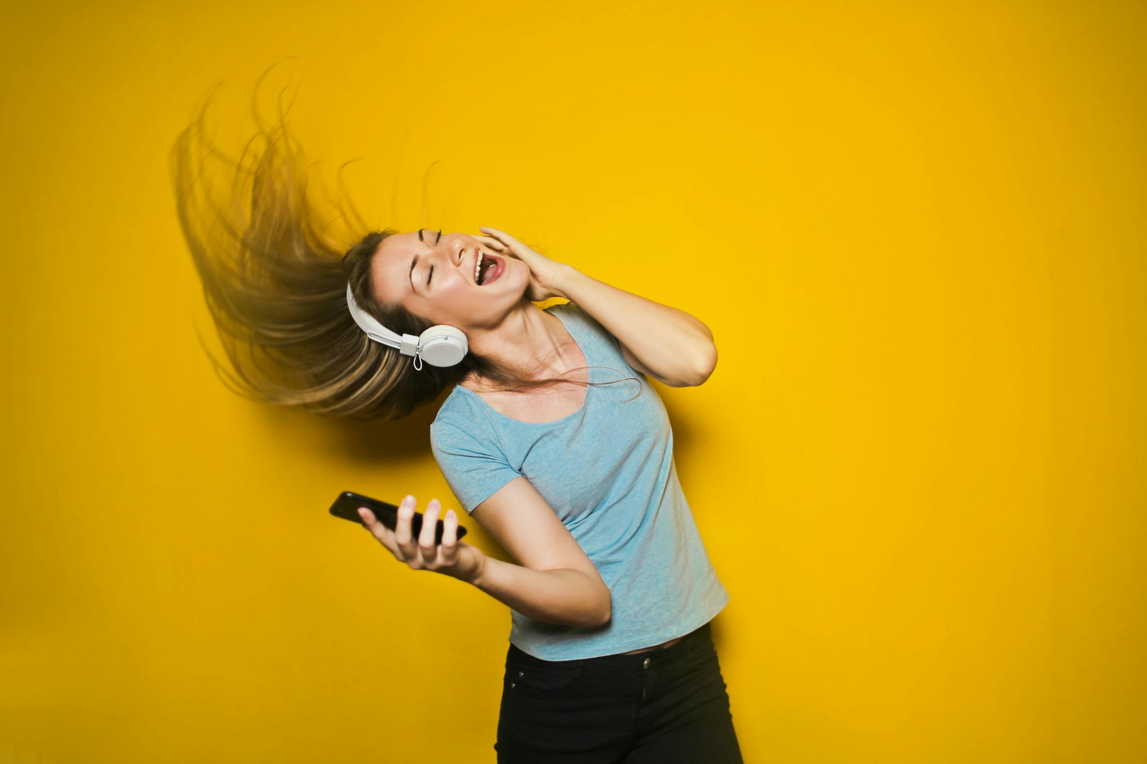 woman listening to music yellow backdrop