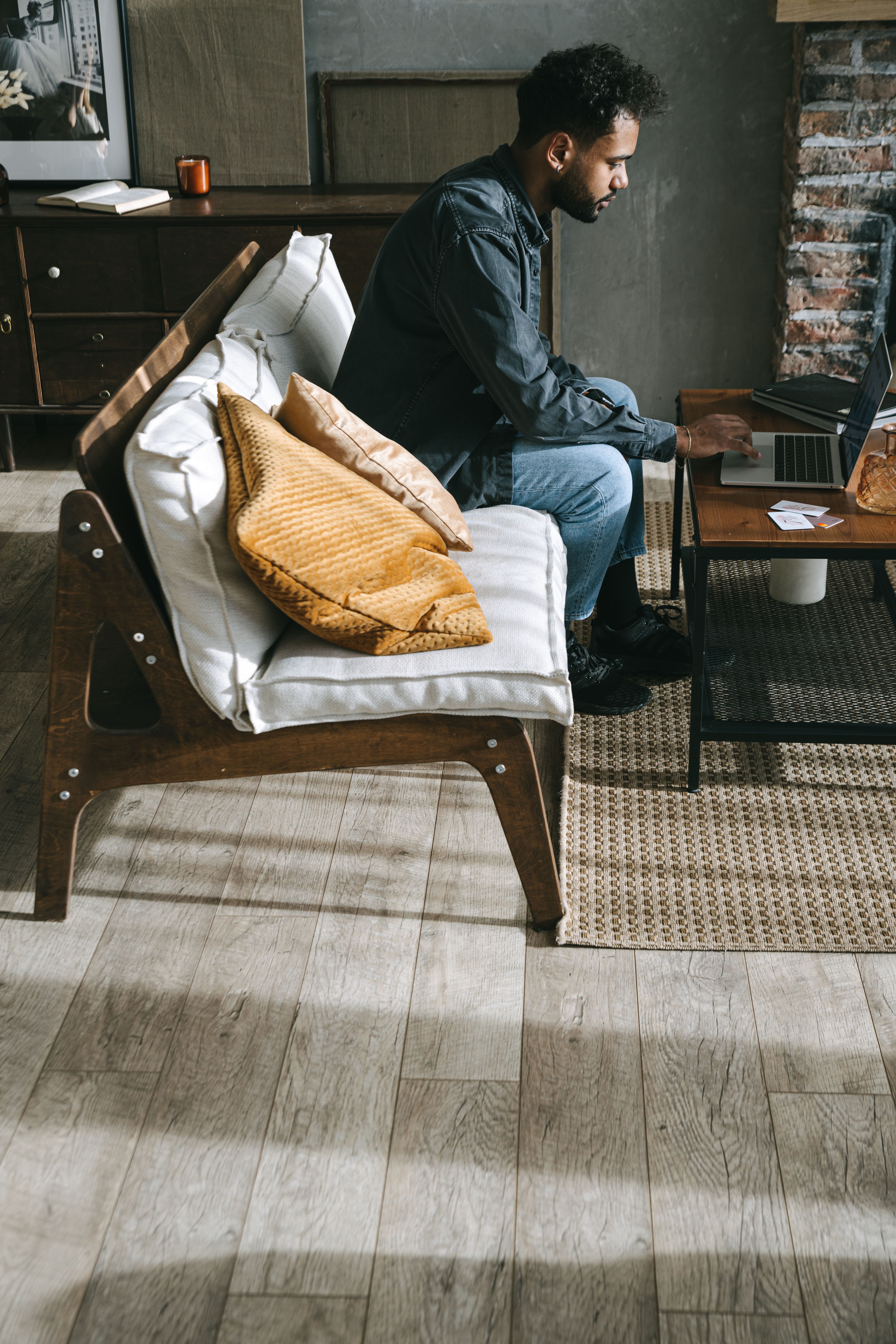A man working remotely from a stylish living room setting with a laptop.
