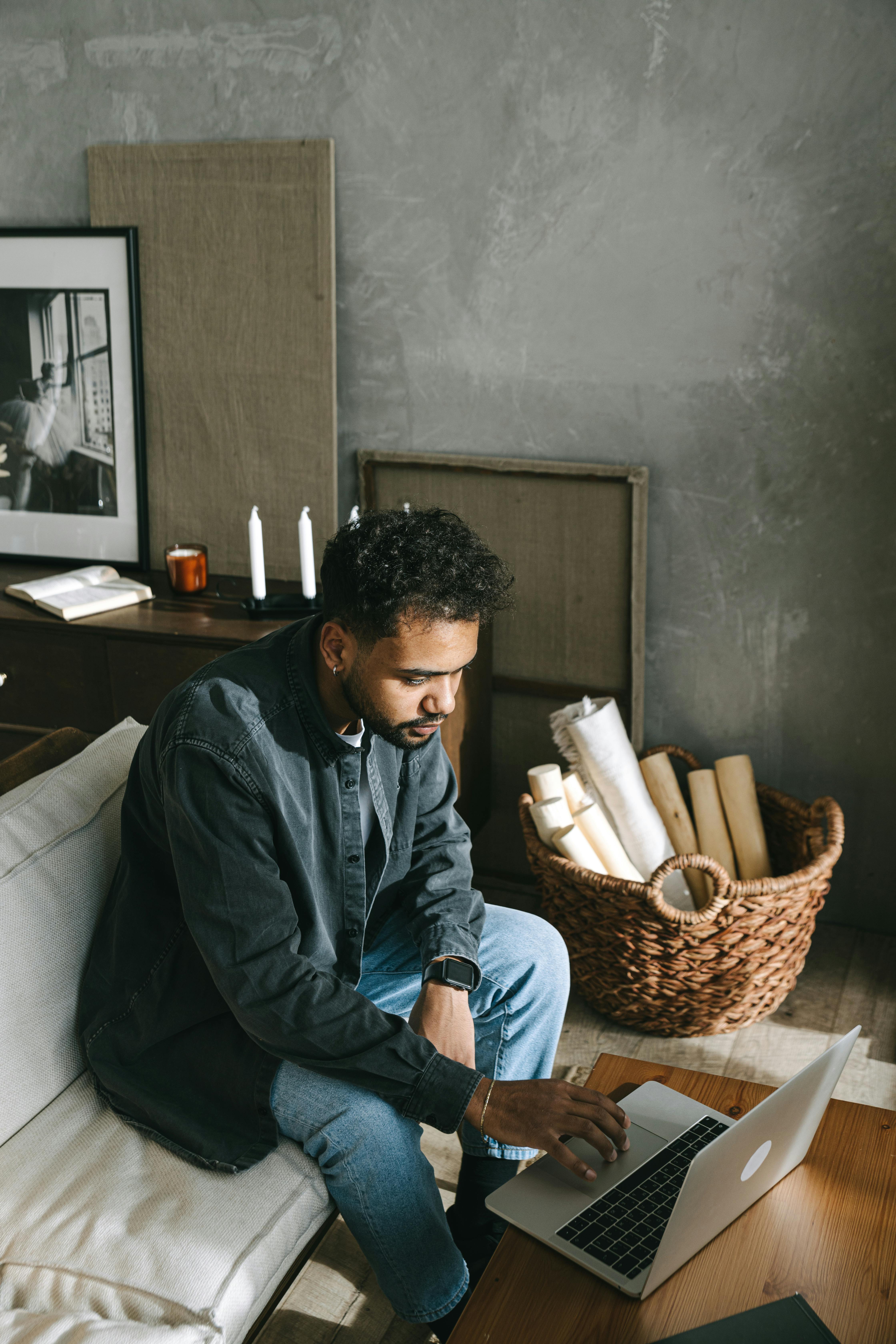 man in blue dress shirt sitting on white couch