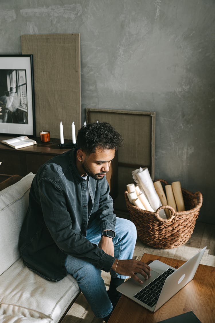 Man In Blue Dress Shirt Sitting On White Couch