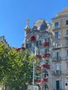 Exterior of majestic house with green trees in front on street in Barcelona under blue sky