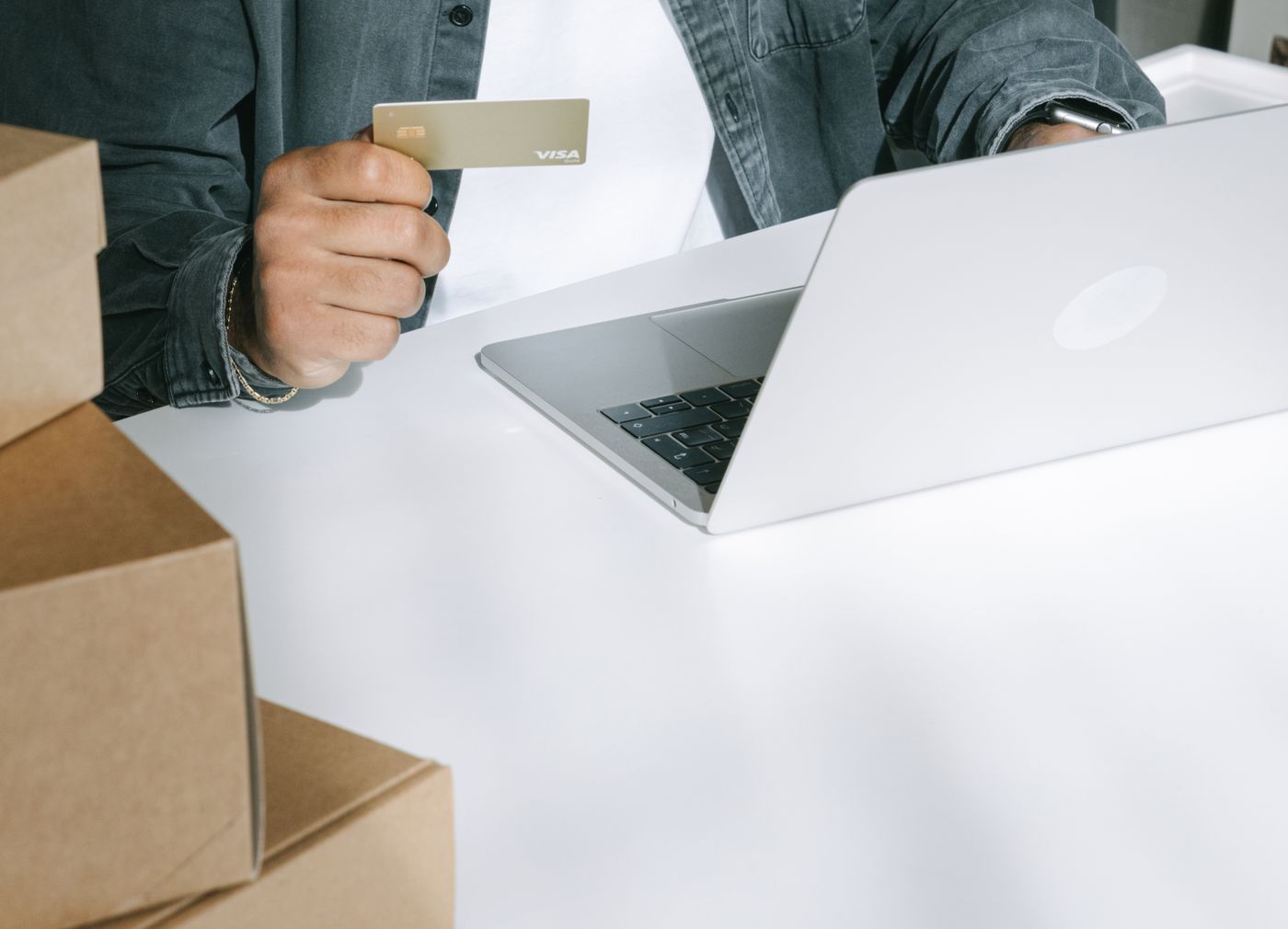 Online shopper using a card beside parcels