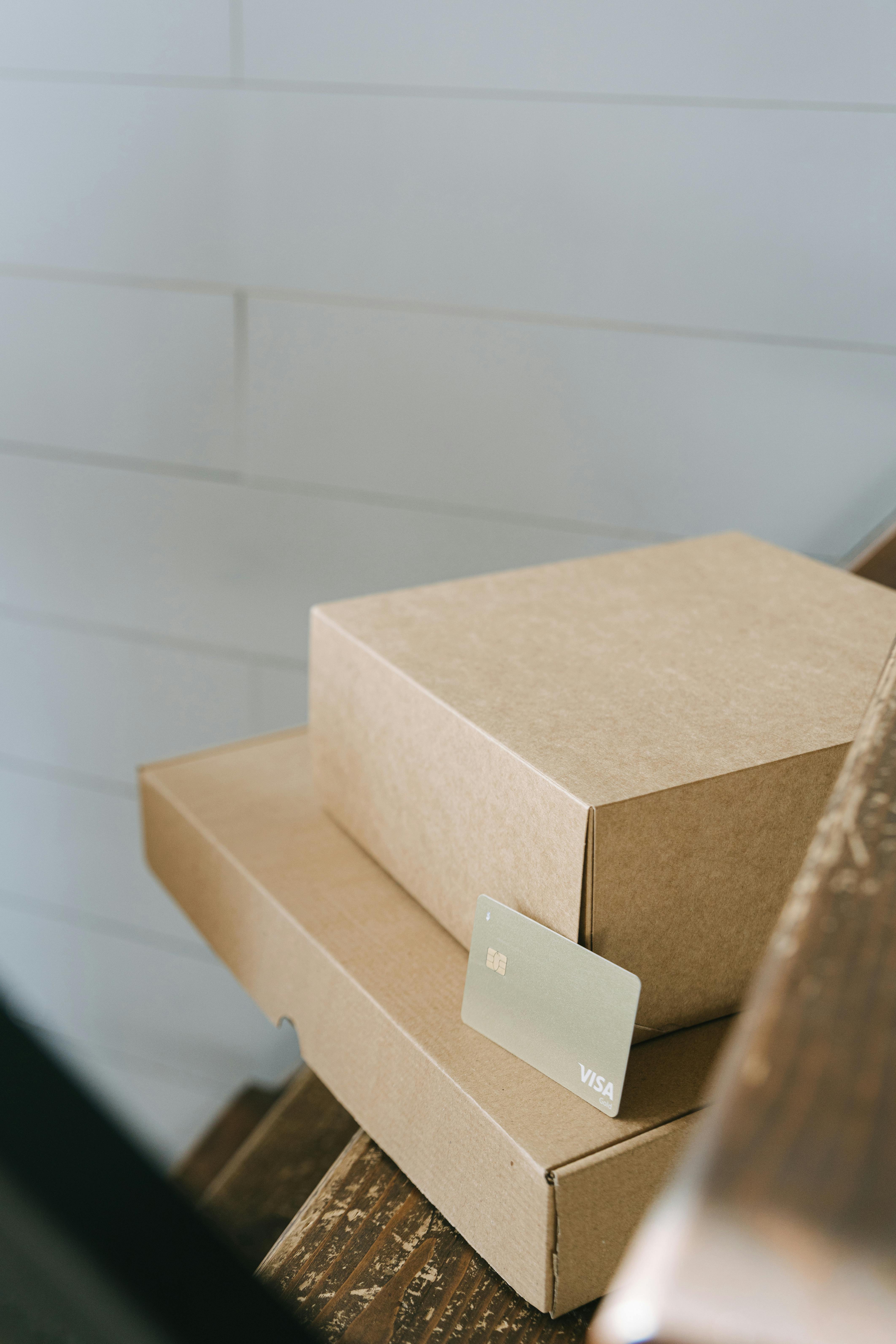 visa card on stacks of brown cardboard box on wooden stairs