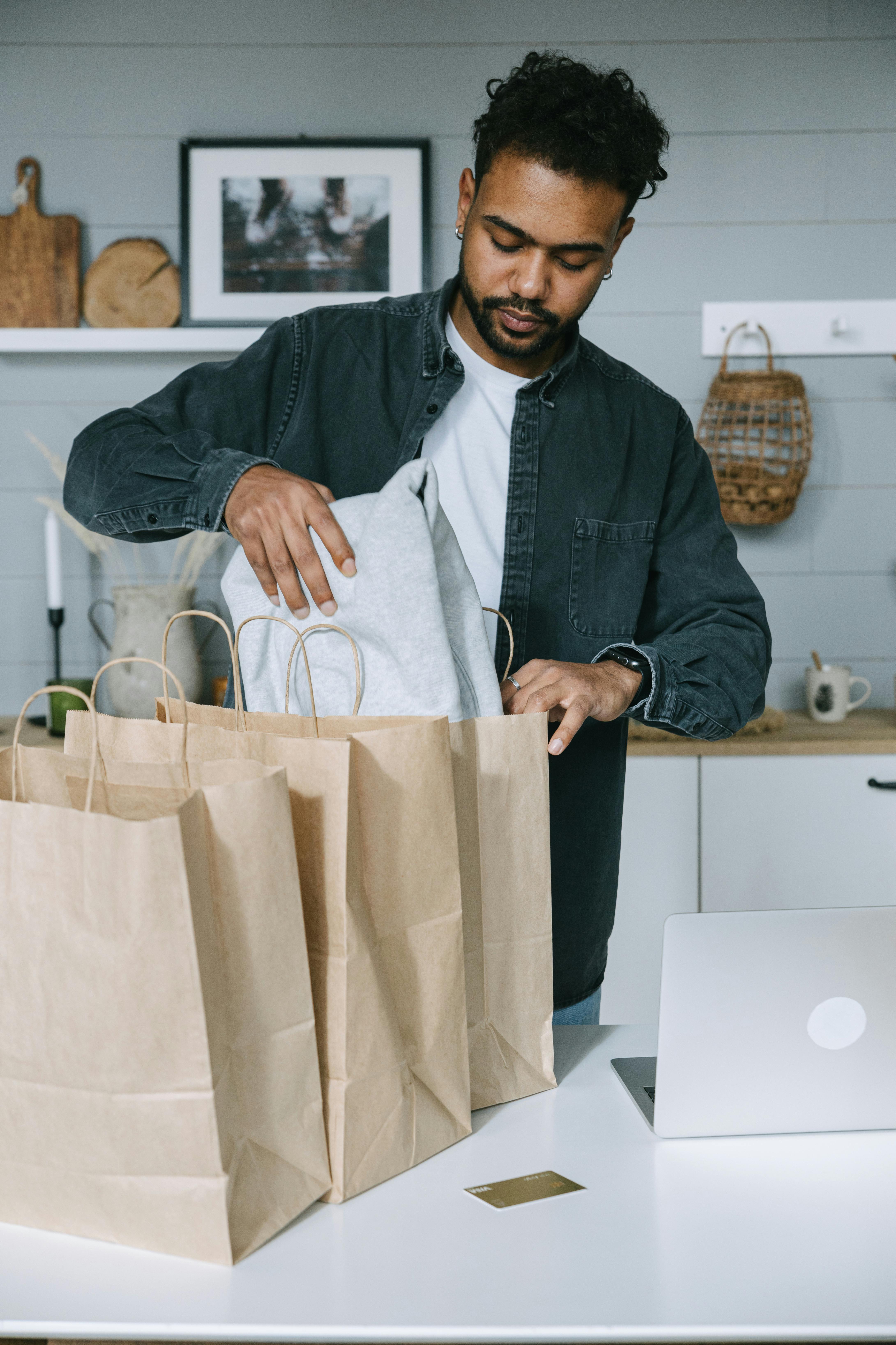 man in black suit jacket holding white paper bag