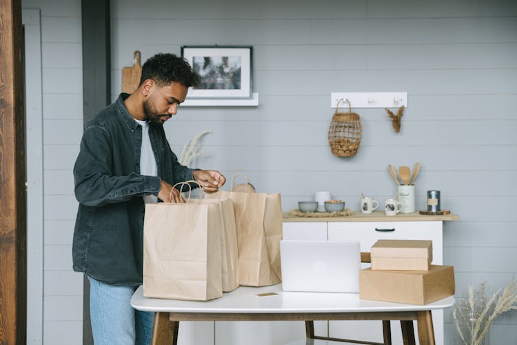 Man Looking At Paper Bags On A Table