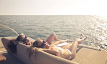 两名女子在游艇上晒日光浴，享受海上的轻松一天