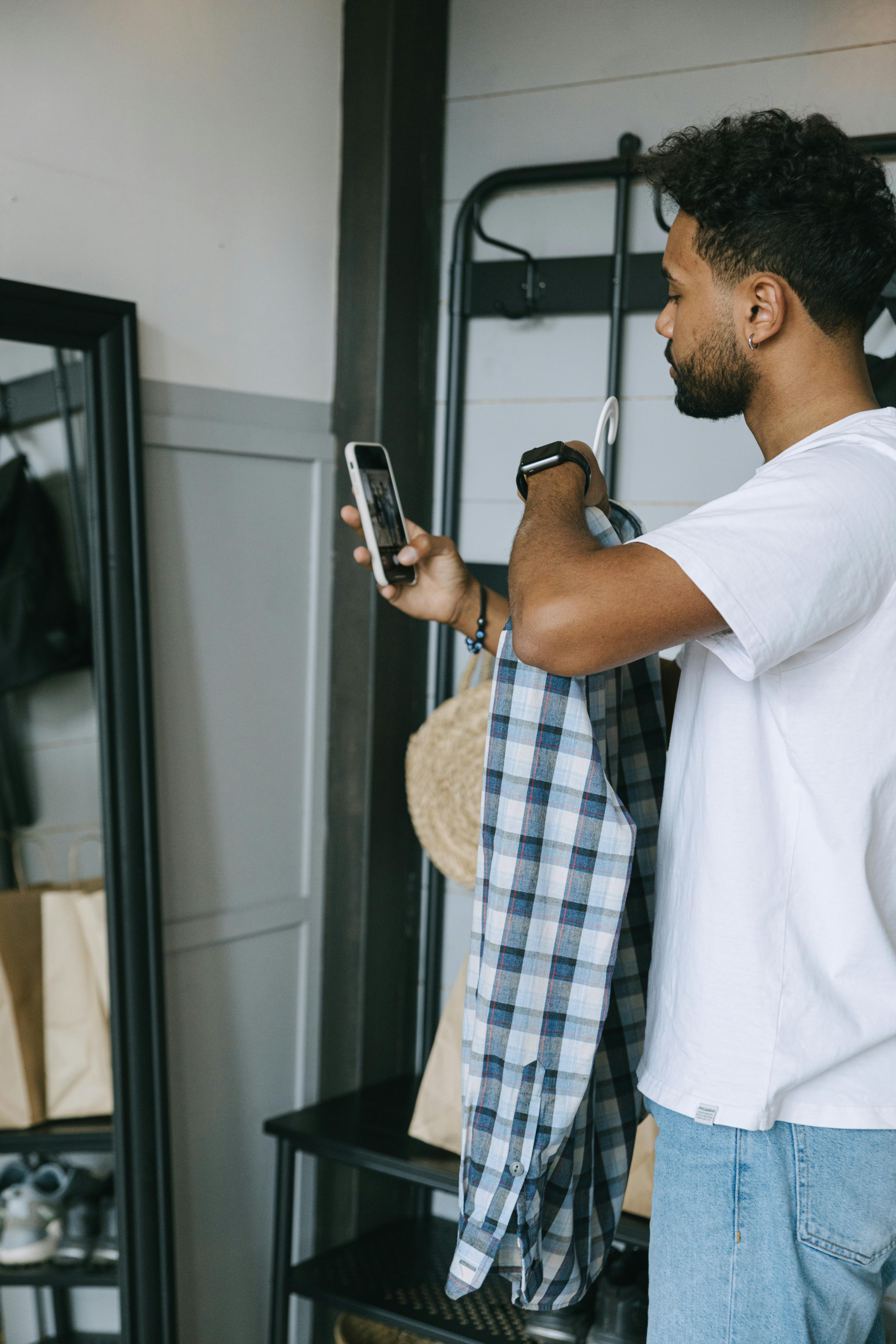 man in white dress shirt holding smartphone