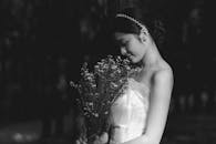 A Grayscale Photo of a Woman Holding a Bouquet of Flowers