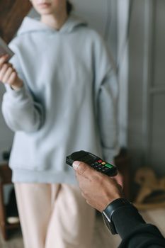 A close-up of a cashless payment using a card reader in a store setting.