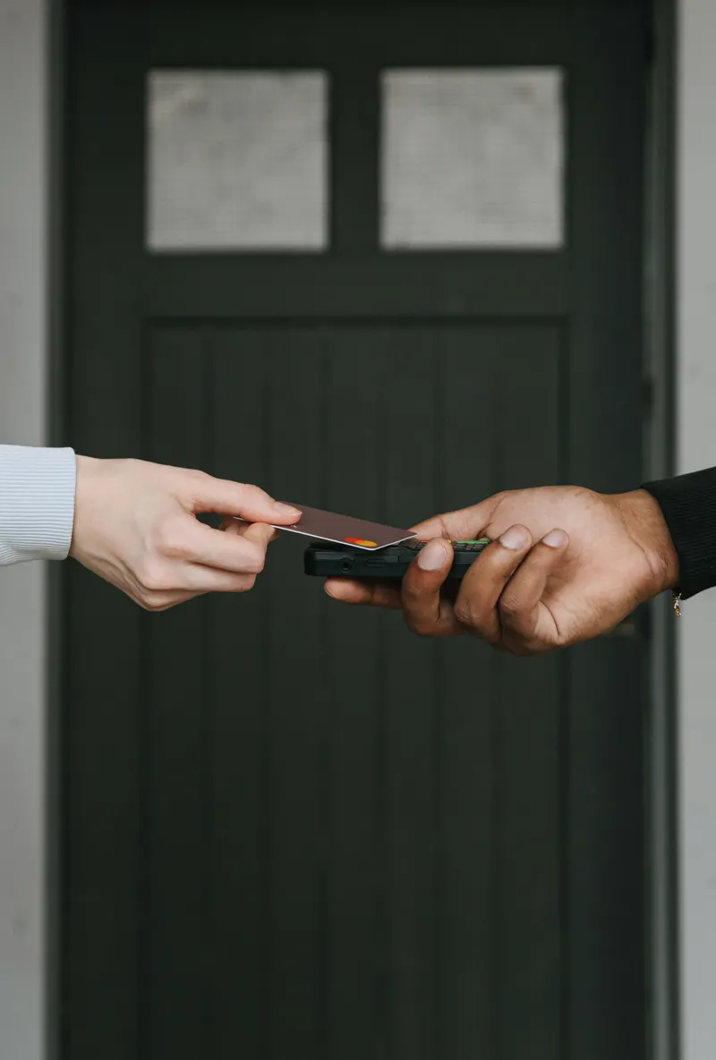 Manos realizando un pago con tarjeta en un terminal.