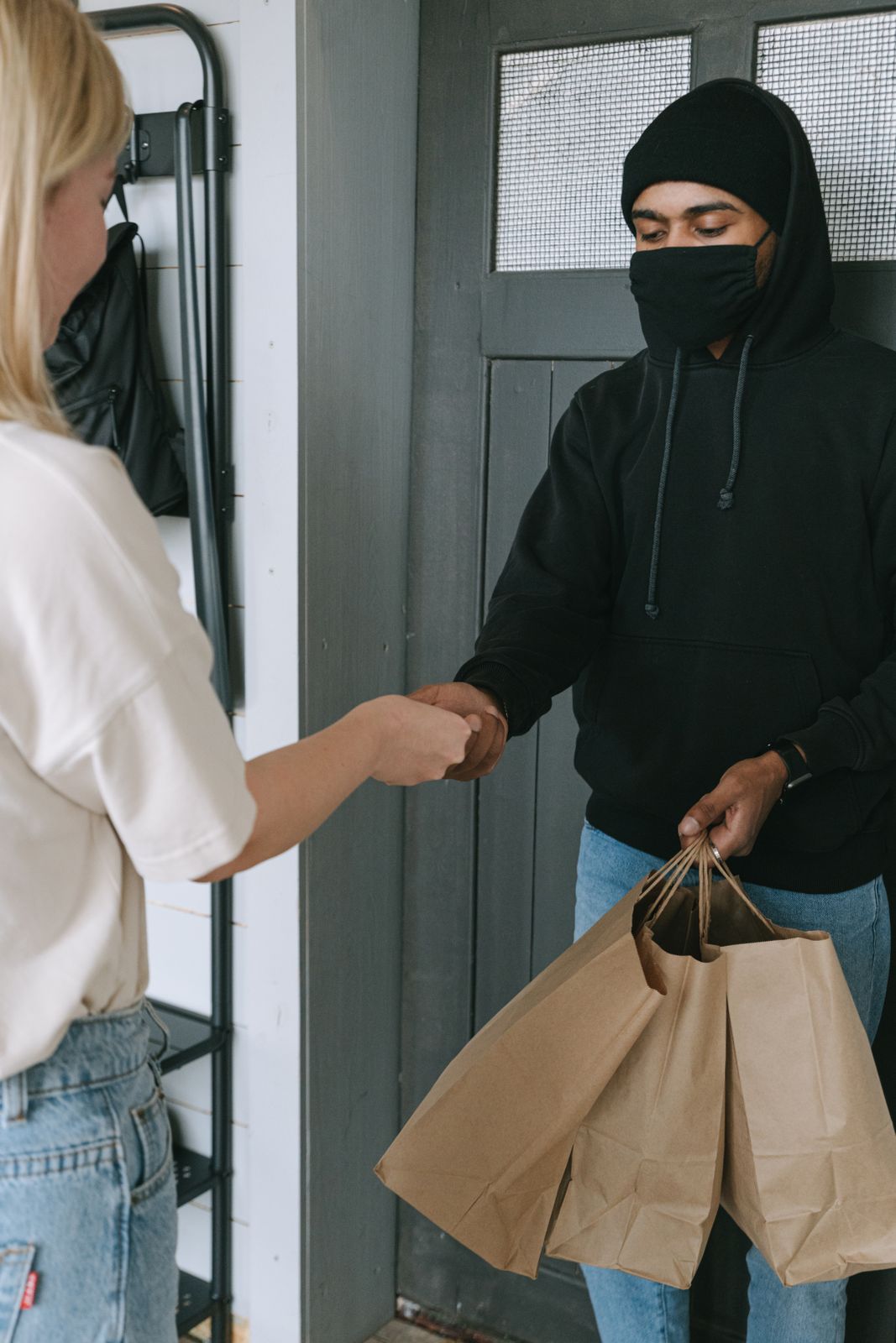 Athedoor delivery driver handing a package to a customer
