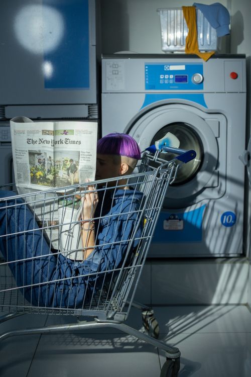 Woman reading Newspaper in a Shopping Cart · Free Stock Photo